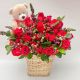 ramo de flores frescas  y rosas con follajes verdes y oso de peluche en canasta-de mimbre 